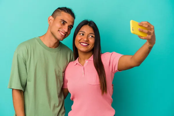 一对年轻的拉丁夫妇 带着一部蓝色背景的手机 — 图库照片