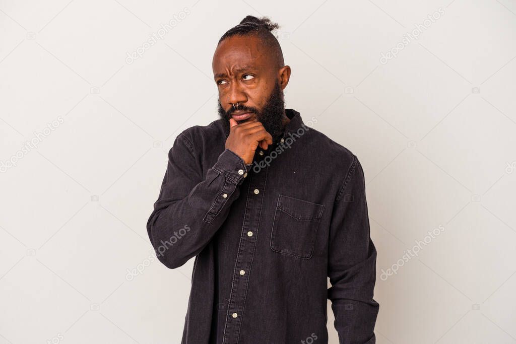 African american man with beard isolated on pink background relaxed thinking about something looking at a copy space.