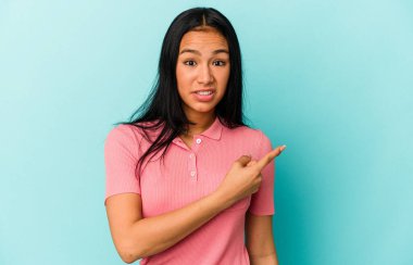 Genç Venezuelalı bir kadın mavi arka planda izole edilmiş.