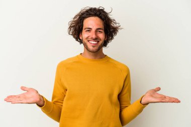 Beyaz arka planda izole genç beyaz adam kollarıyla ölçek yapar, mutlu ve kendinden emin hisseder..