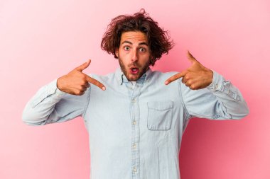 Kafkasyalı genç adam pembe bakkal sahasında izole edilmiş parmaklarıyla aşağıya bakıyor, olumlu bir his..