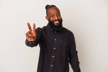 Pembe arka planda sakallı Afrikalı Amerikalı adam zafer işareti gösteriyor ve gülümsüyor..