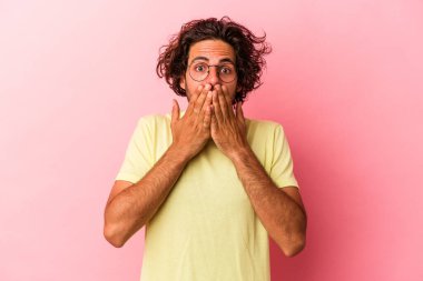 Pembe fırında izole edilmiş genç beyaz adam şok olmuş, ağzı ellerle kaplanmış, yeni bir şey keşfetmek için sabırsızlanıyor..