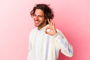 Kafkasyalı genç adam pembe fırında izole edilmiş neşeli ve kendinden emin..