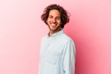 Pembe fırında izole edilmiş genç beyaz adam ellerini kalçasında tutuyor..