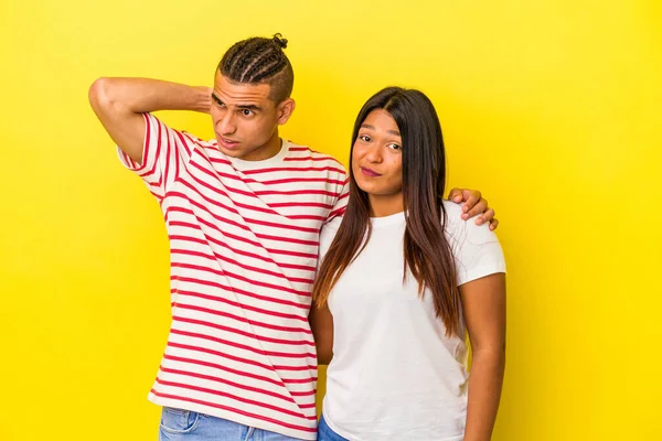 Sarı Arka Planda Izole Edilmiş Genç Latin Çift Başlarının Arkasına — Stok fotoğraf