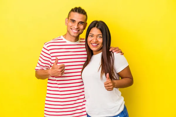 Sarı Arka Planda Izole Edilmiş Genç Latin Çift Gülümsüyor Başparmağını — Stok fotoğraf