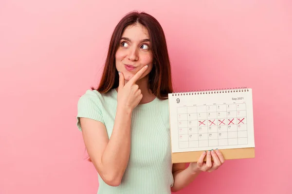 Giovane Donna Caucasica Possesso Calendario Isolato Sfondo Rosa Guardando Lateralmente — Foto Stock