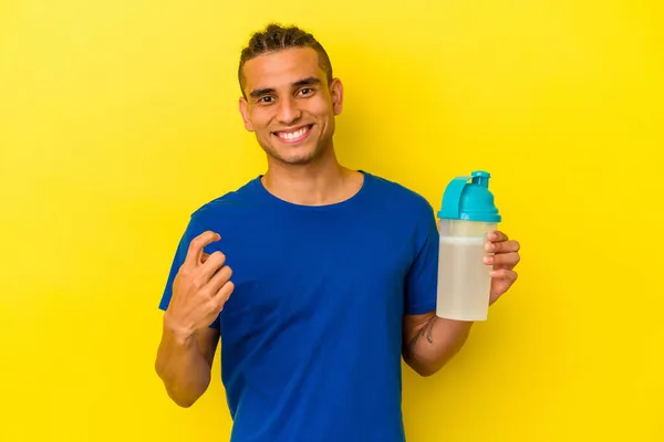 Mladý Venezuelský Muž Pije Proteinový Koktejl Izolovaný Žlutém Pozadí Ukazuje — Stock fotografie