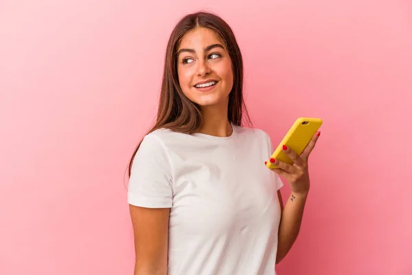 Joven Mujer Caucásica Sosteniendo Teléfono Móvil Aislado Sobre Fondo Rosa —  Fotos de Stock