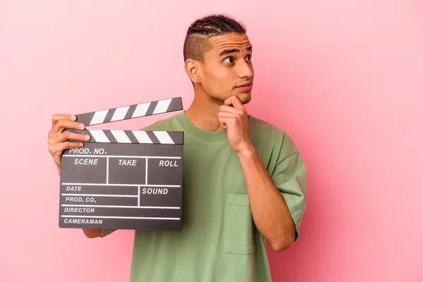 Young Venezuelan Man Holding Clapperboard Isolated Pink Background Looking Sideways — Stock Photo, Image