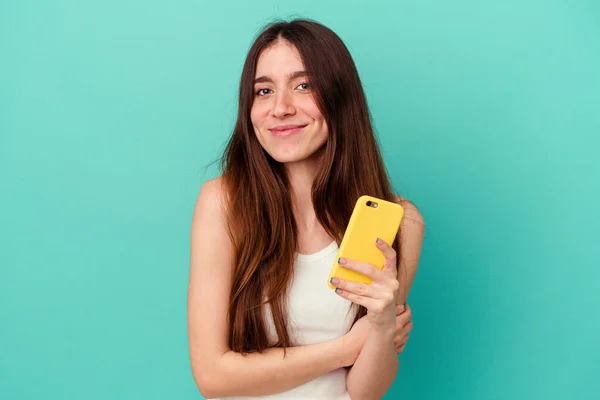 Mladá Běloška Drží Mobilní Telefon Izolované Modrém Pozadí Směje Baví — Stock fotografie