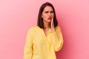Pembe arka planda izole genç beyaz kadın güçlü bir diş ağrısı, azıdişi ağrısı var..