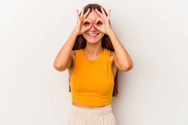 Beyaz arka planda izole edilmiş beyaz tenli genç bir kadın gözlerinde sorun olmadığını gösteriyor.