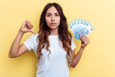 Sarı arka planda izole edilmiş banknotları tutan genç melez kadın hoşlanmadığı bir jestte bulundu. Anlaşmazlık konsepti.