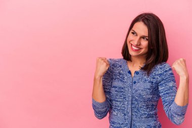 Pembe arka planda izole edilmiş beyaz bir kadın zaferden sonra yumruğunu kaldırıyor, kazanan konsept.