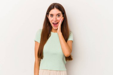Beyaz arka planda izole genç beyaz kadın yüksek sesle bağırıyor, gözleri açık ve elleri gergin tutuyor..
