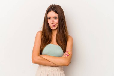 Beyaz arka planda izole edilmiş, hoşnutsuzca kaşlarını çatmış, kollarını kavuşturmuş genç beyaz bir kadın..