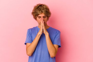 Pembe arka planda soyutlanmış, kendini adamış, dindar, ilahi ilhamı arayan genç, beyaz bir adam..