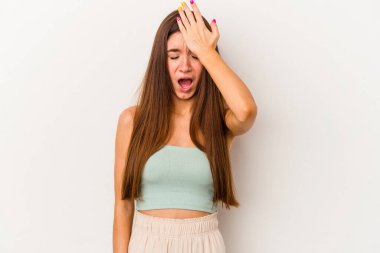 Beyaz arka planda izole edilmiş genç beyaz bir kadın bir şeyi unutuyor. Alnına avuç içi ve gözlerini kapayarak vuruyor..