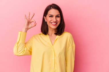 Genç beyaz kadın pembe arka planda izole edilmiş neşeli ve kendinden emin, iyi bir jest yapıyor..