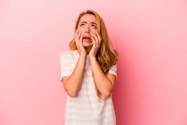 Beyaz tenli sarışın kadın pembe arka planda izole edilmiş sızlanıyor ve ağlıyordu..