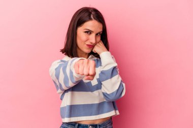 Pembe arka planda izole edilmiş genç beyaz kadın bir tartışma yüzünden yumruk, öfke, kavga ve boks atıyor..