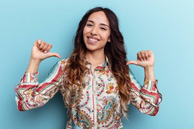 Mavi arka planda izole edilmiş genç Meksikalı kadın gururlu ve kendinden emin hissediyor, örnek olarak.
