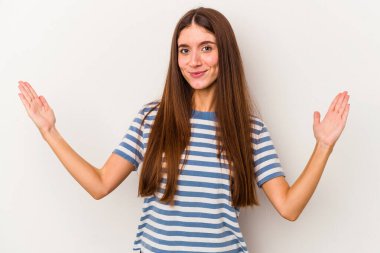 Beyaz arka planda izole edilmiş genç beyaz bir kadın. Elinde parmakları olan, gülümseyen ve kendinden emin bir şey tutuyor..