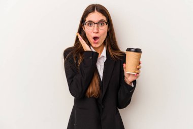 Beyaz arka planda izole edilmiş kahvesini elinde tutan beyaz iş kadını şaşırdı ve şok oldu..