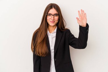 Beyaz arka planda izole edilmiş beyaz iş kadını gülümseyerek beş numarayı parmaklarıyla gösteriyor..