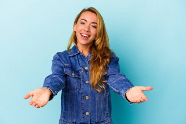 Mavi arka planda izole edilmiş beyaz kadın hoş bir ifade sergiliyor..