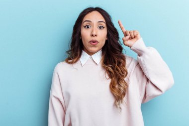 Genç Meksikalı bir kadın mavi arka planda izole edilmiş. Harika bir fikri var. Yaratıcılık kavramı..