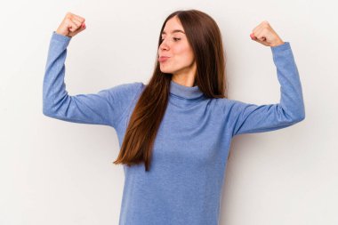 Beyaz arka planda izole edilmiş genç beyaz bir kadın güçlü bir hareket gösteriyor, kollarıyla, kadınsı gücün sembolü.