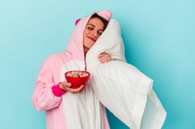 Mavi arka planda tek boynuzlu at pijaması giyen beyaz bir kadın.