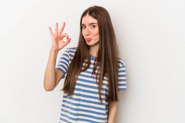 Beyaz arka planda izole edilmiş genç beyaz kadın bir göz kırptı ve elleriyle iyi bir jest yaptı..