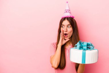 Pembe arka planda izole edilmiş bir doğum gününü kutlayan beyaz bir kadın gizli bir sıcak fren haberinden bahsediyor.