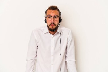 Beyaz arka planda izole edilmiş dövmeleri olan beyaz tenli beyaz pazarlamacı omuzlarını silkeliyor ve gözleri açık..