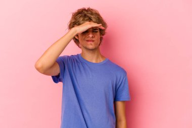 Makyajlı beyaz bir adam pembe arka planda izole edilmiş tapınaklara dokunuyor ve baş ağrısı çekiyor..