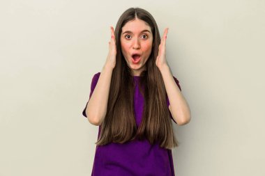 Sarı arka planda izole edilmiş genç beyaz kadın şaşırdı ve şok oldu..