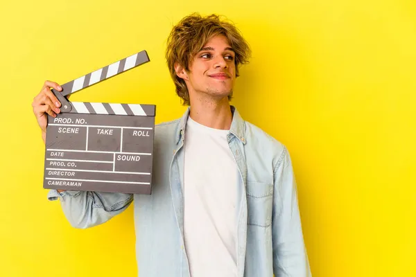 Young Caucasian Man Makeup Holding Clapperboard Isolated Yellow Background Dreaming — Stock Photo, Image