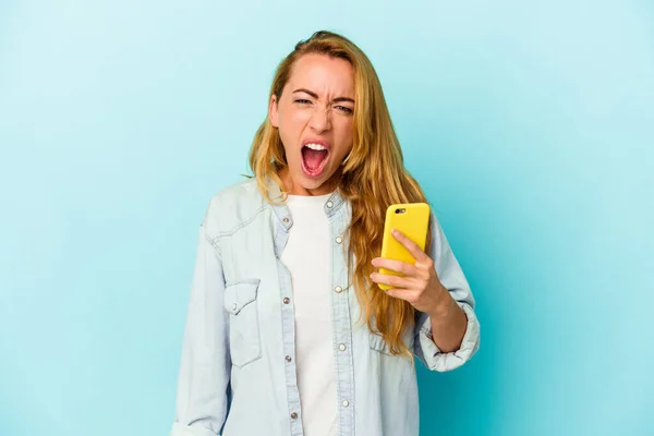 Mulher Caucasiana Segurando Celular Isolado Fundo Azul Gritando Muito Irritado — Fotografia de Stock