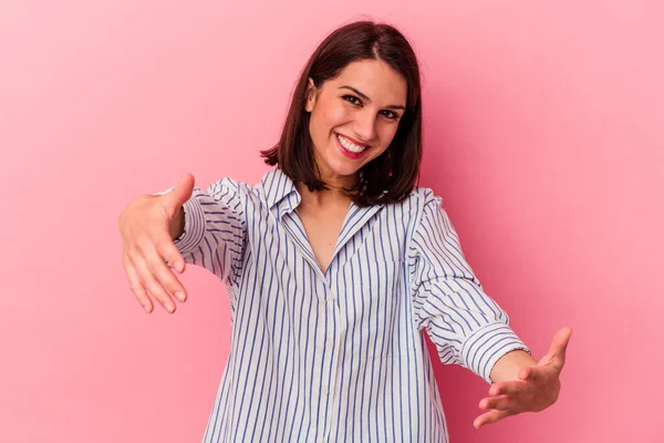 Pembe arka planda soyutlanmış beyaz bir kadın hoş bir yüz ifadesi sergiliyor..