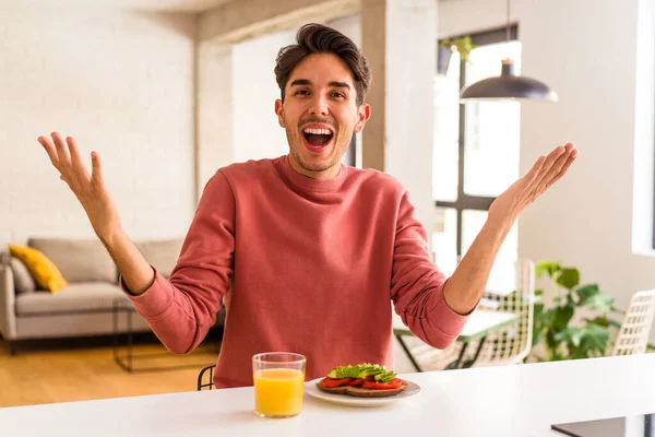 Joven Mestizo Desayunando Cocina Recibiendo Una Grata Sorpresa Excitado Levantando — Foto de Stock