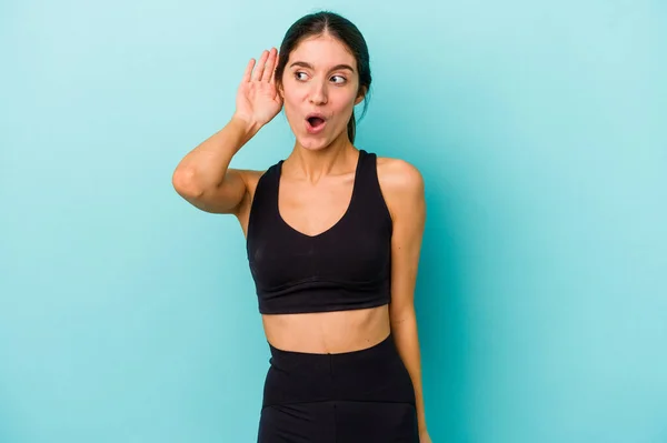 Joven Mujer Atlética Caucásica Aislada Sobre Fondo Azul Tratando Escuchar —  Fotos de Stock