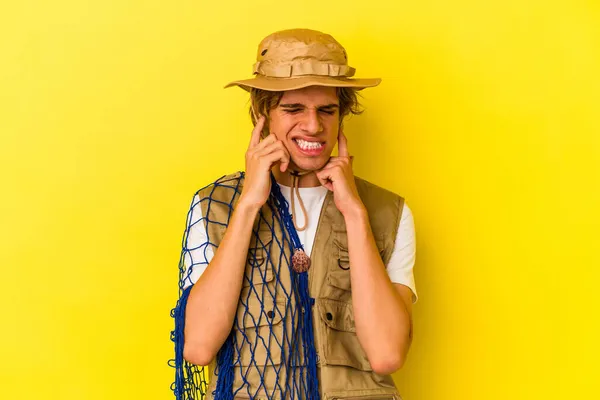Young Fisherman Makeup Holding Net Isolated Yellow Background Covering Ears — Stock Photo, Image