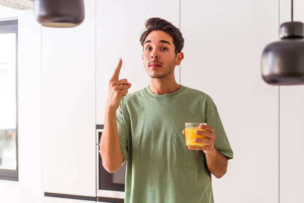 Hombre Joven Raza Mixta Bebiendo Jugo Naranja Cocina Mostrando Número — Foto de Stock