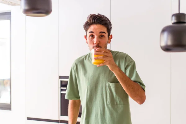 Молодой Человек Смешанной Расы Пьет Апельсиновый Сок Кухне — стоковое фото