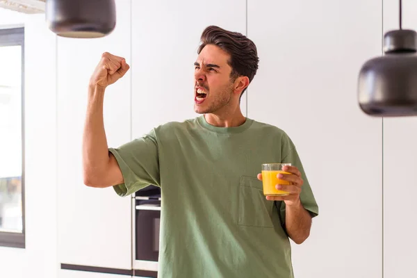 Joven Hombre Raza Mixta Bebiendo Jugo Naranja Cocina Levantando Puño — Foto de Stock