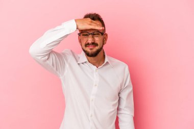 Pembe arka planda izole edilmiş beyaz dövmeli genç bir adam tapınaklara dokunuyor ve baş ağrısı çekiyor..